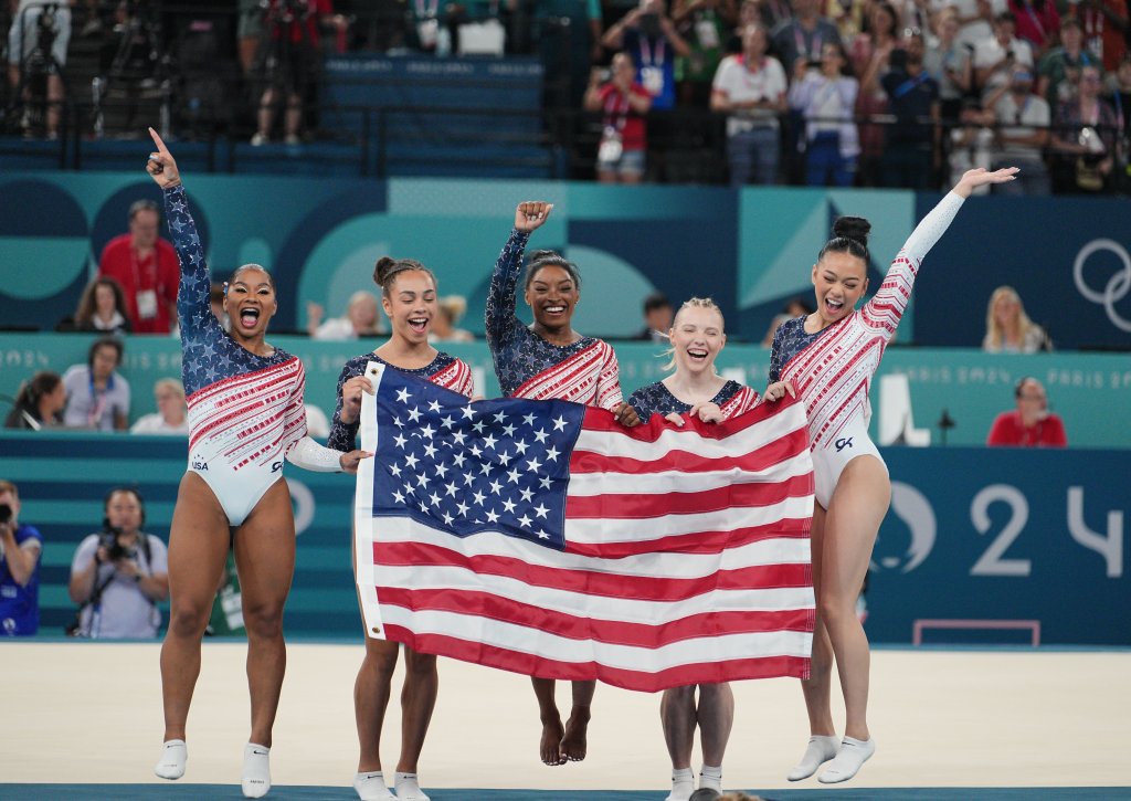 Left to right: Chiles, Hezly Rivera, Biles, Jade Carey, and Suni Lee celebrate with the American flag