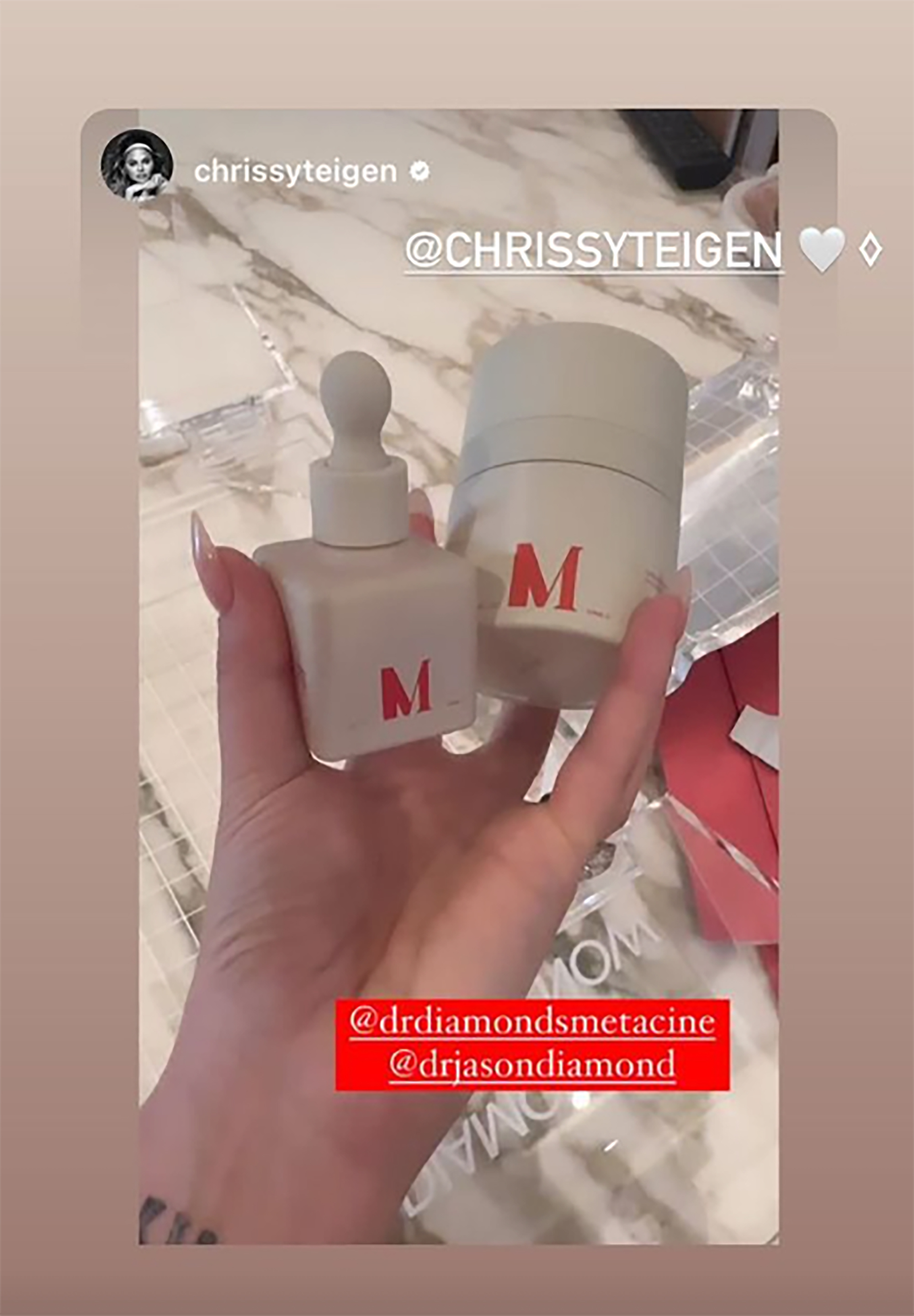 Chrissty Teigen holding metacine bottles