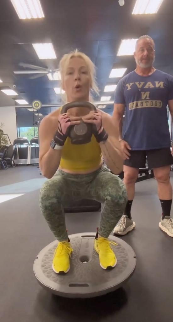 jennie garth squatting on a bosu half ball with a kettlebell