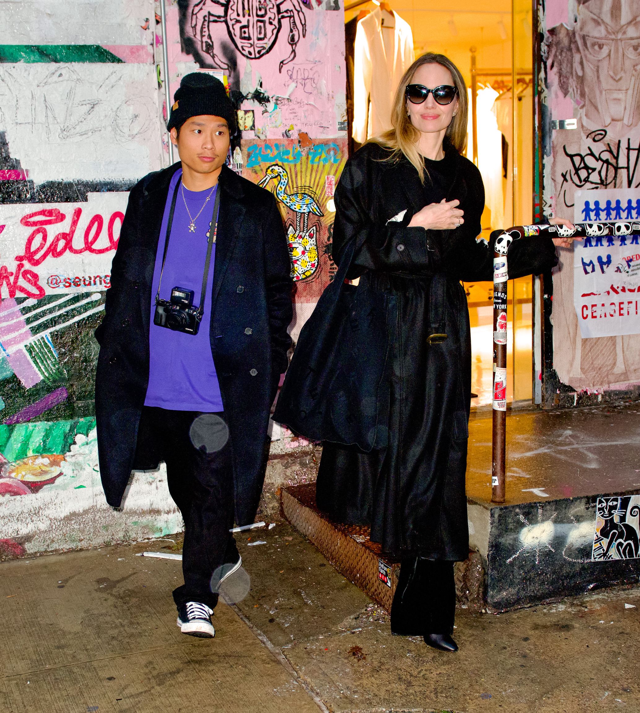 angelina jolie and pax jolie-pitt walking out of a building