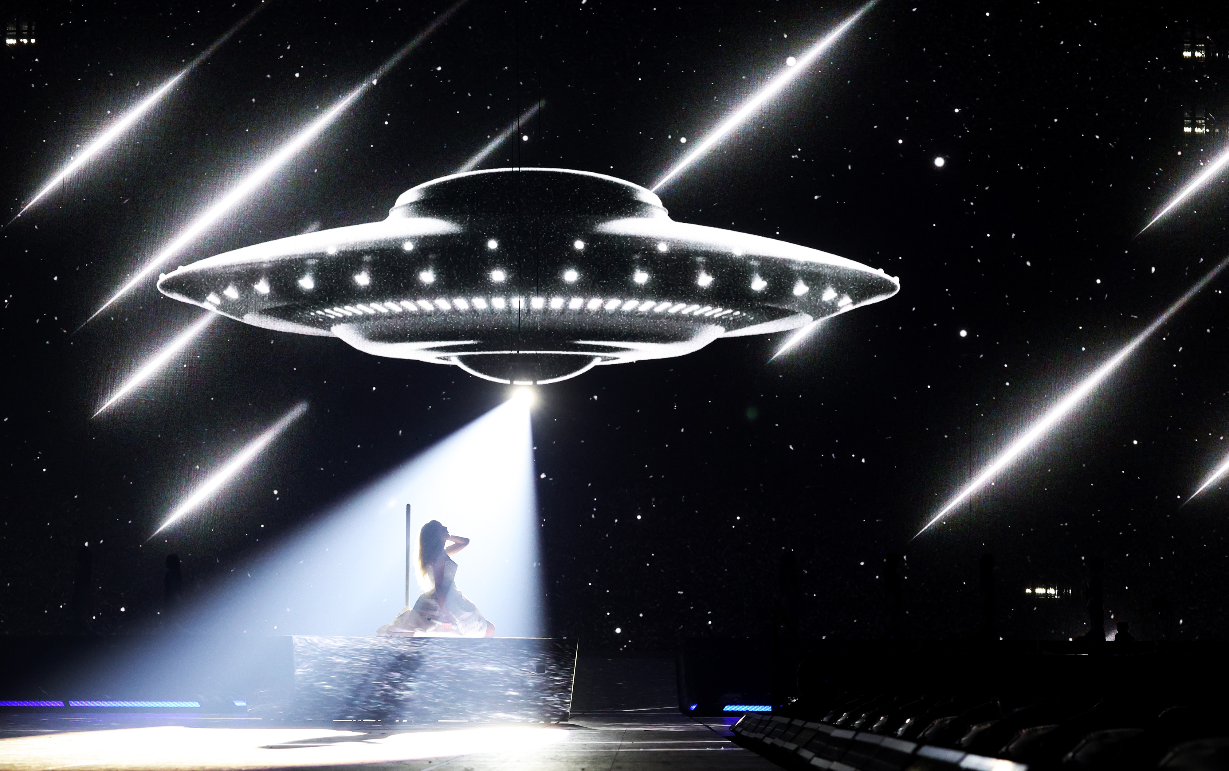 Taylor Swift performing under a UFO light