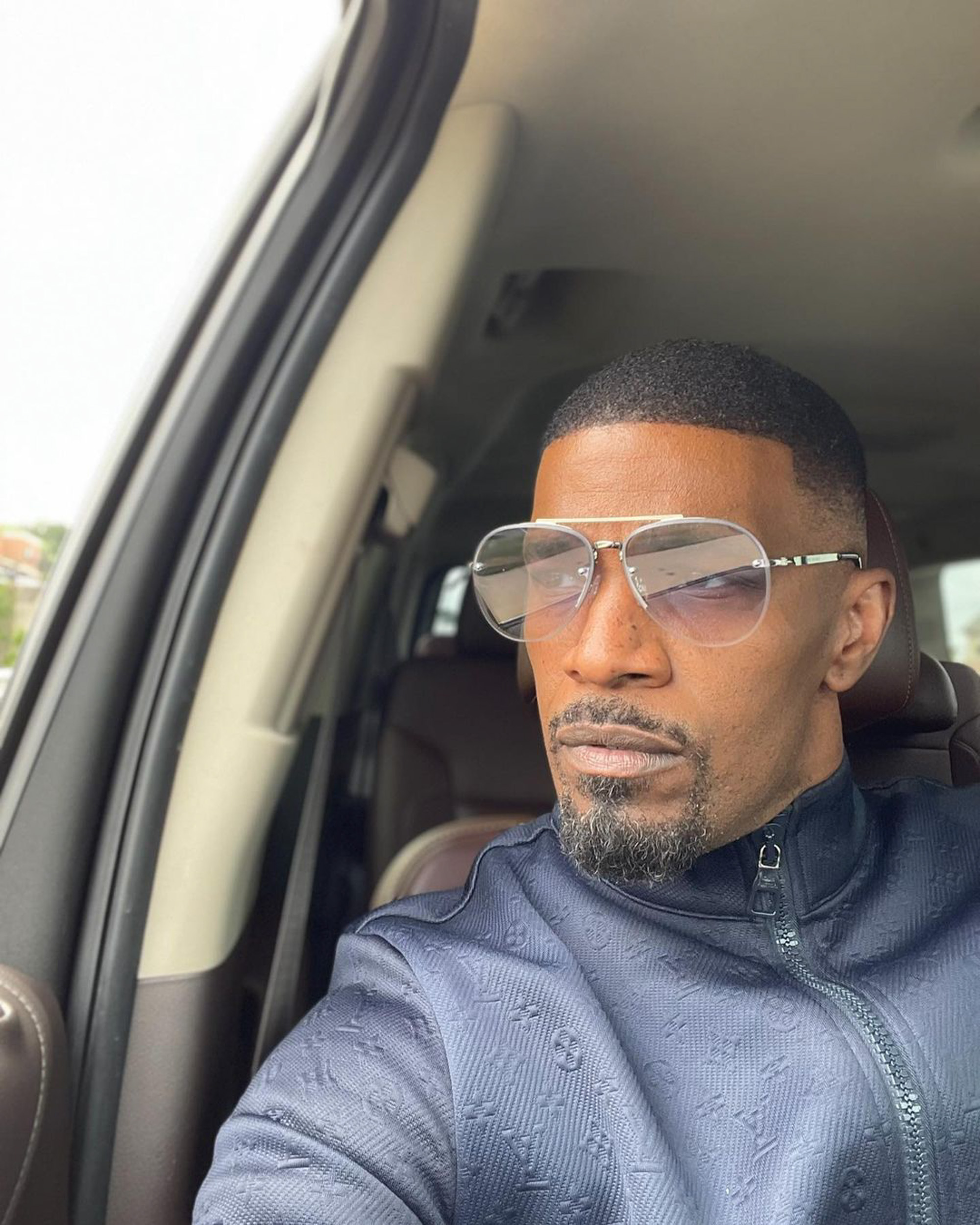 Jamie Foxx posing for a selfie in a car