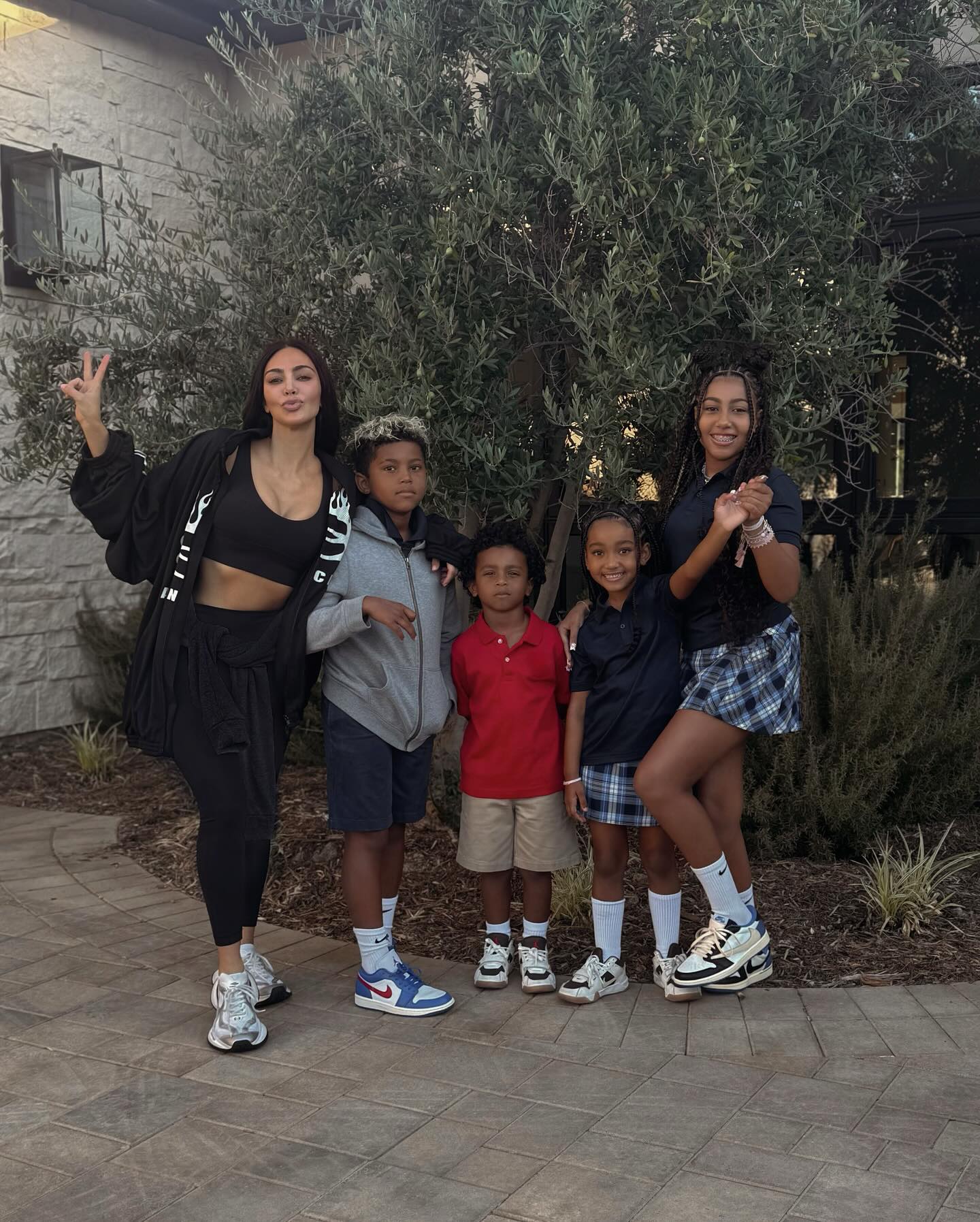 Kim Kardashian, Saint West, Psalm West, Chicago West and North West posing in front of a Christmas tree