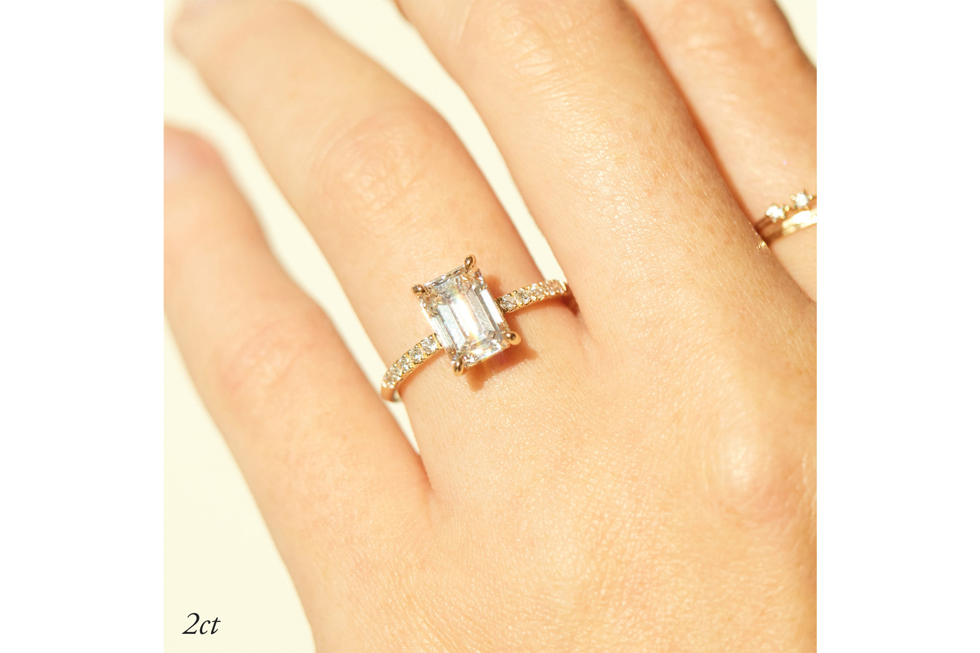 A hand with an emerald-cut ring on it