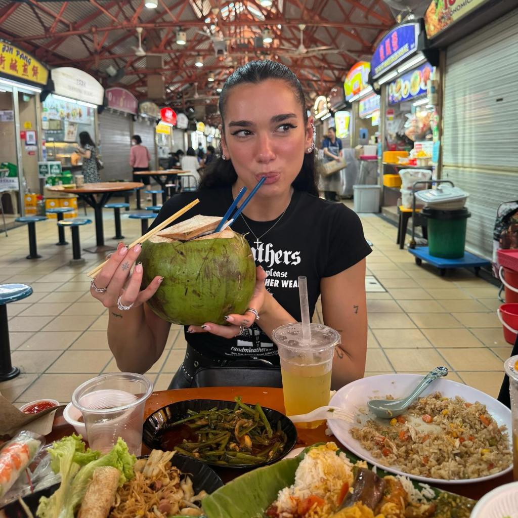 Dua Lipa sips from a coconut while on tour.