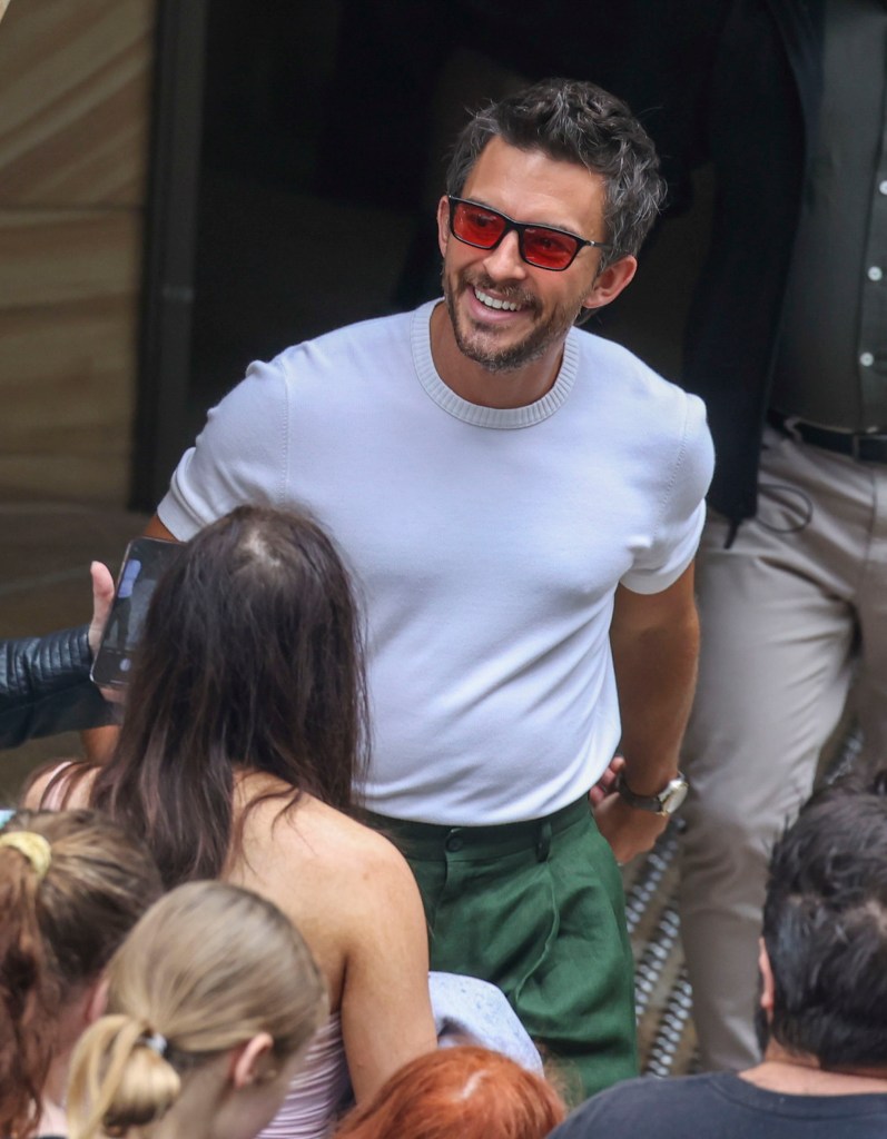 Jonathan Bailey beams while meeting fans outside of his home in Sydney.