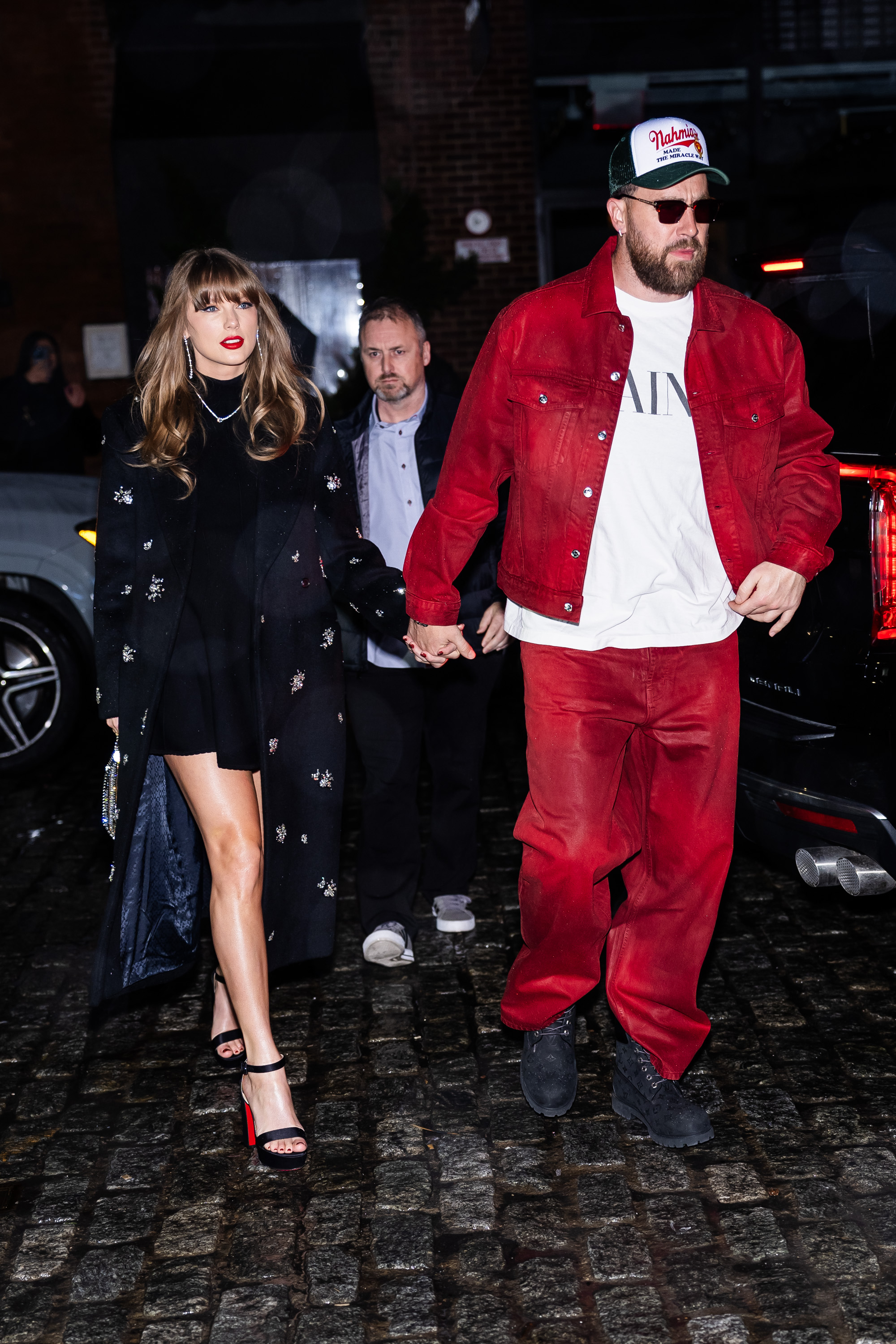 Taylor Swift and Travis Kelce holding hands.