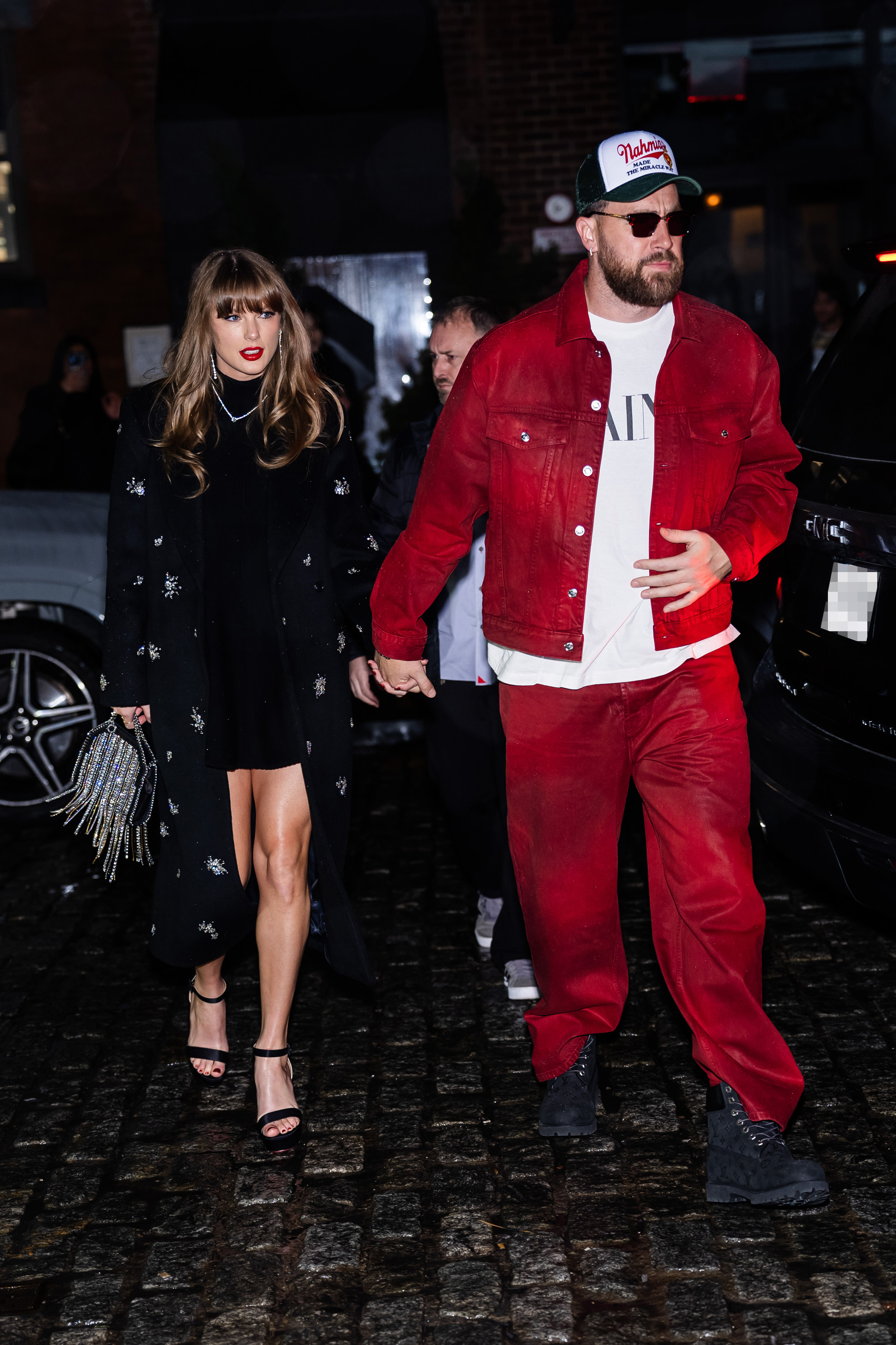 Taylor Swift and Travis Kelce holding hands.