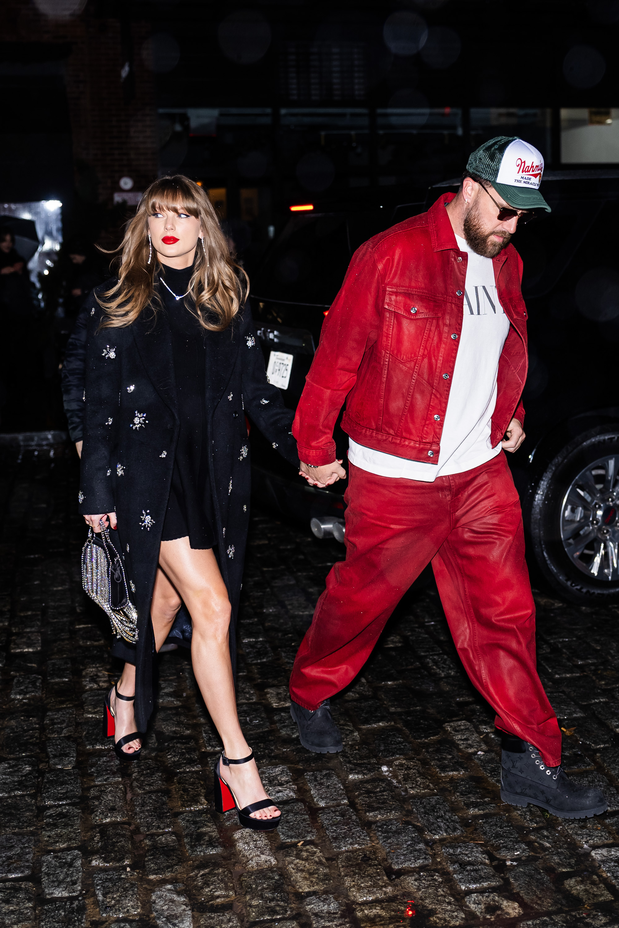 Taylor Swift and Travis Kelce holding hands.