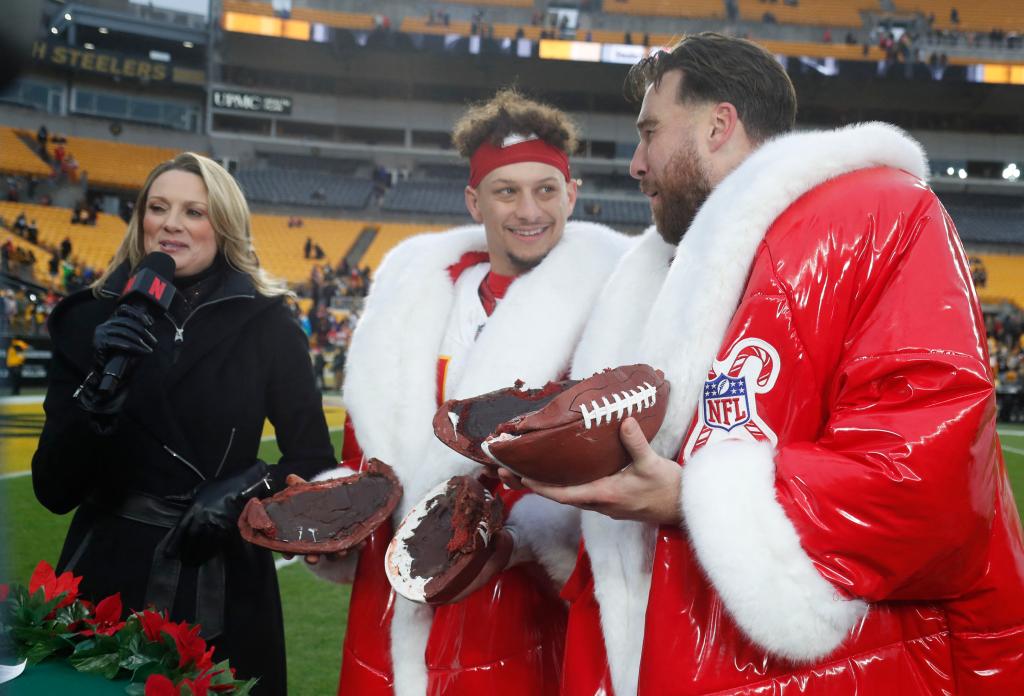 Patrick Mahomes and Travis Kelce holding Netflix's football cake after their Kansas City Chiefs game on Christmas Day Wednesday. 