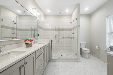Bathroom - mid-sized coastal master ceramic tile, gray floor and double-sink bathroom idea in Milwaukee with beige cabinets, an undermount sink, quartz countertops, a hinged shower door and white countertops