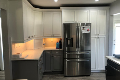Medium sized traditional l-shaped kitchen pantry in Miami with a double-bowl sink, raised-panel cabinets, white cabinets, granite worktops, white splashback, granite splashback, stainless steel appliances, laminate floors, an island, grey floors, white worktops and a coffered ceiling.