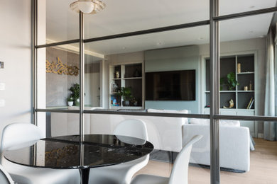 This is an example of a large modern kitchen/dining room in Rome with grey walls and light hardwood flooring.