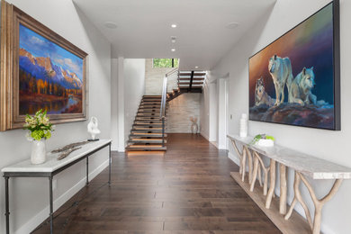 Large minimalist medium tone wood floor and brown floor foyer photo in Other with white walls