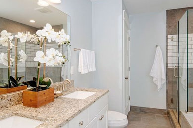 Large elegant master beige tile and stone tile double-sink, ceramic tile and beige floor wet room photo in Detroit with shaker cabinets, white cabinets, a two-piece toilet, white walls, an undermount sink, granite countertops, a built-in vanity and a hinged shower door