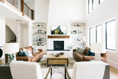 Inspiration for a large traditional open plan games room in Salt Lake City with white walls, light hardwood flooring, a standard fireplace, a brick fireplace surround, a wall mounted tv, brown floors, a vaulted ceiling and a chimney breast.