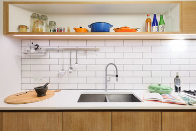 Example of a mid-sized trendy galley porcelain tile and gray floor eat-in kitchen design in London with an undermount sink, flat-panel cabinets, medium tone wood cabinets, concrete countertops, white backsplash, subway tile backsplash, stainless steel appliances, a peninsula and white countertops