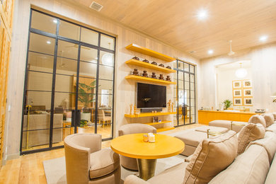 Example of a large transitional open concept light wood floor and beige floor living room design in Miami with beige walls, no fireplace and a wall-mounted tv