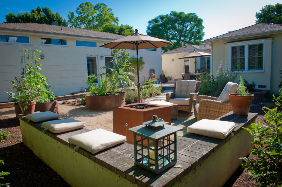 Inspiration for a mid-sized timeless backyard decomposed granite patio remodel in Los Angeles with a fire pit