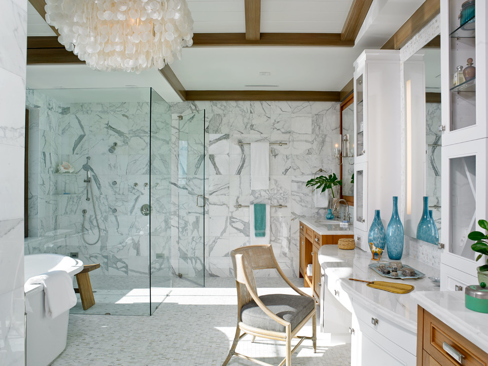 Inspiration for a world-inspired bathroom in Miami with recessed-panel cabinets, a submerged sink, medium wood cabinets, a freestanding bath, an alcove shower, white tiles and mosaic tile flooring.