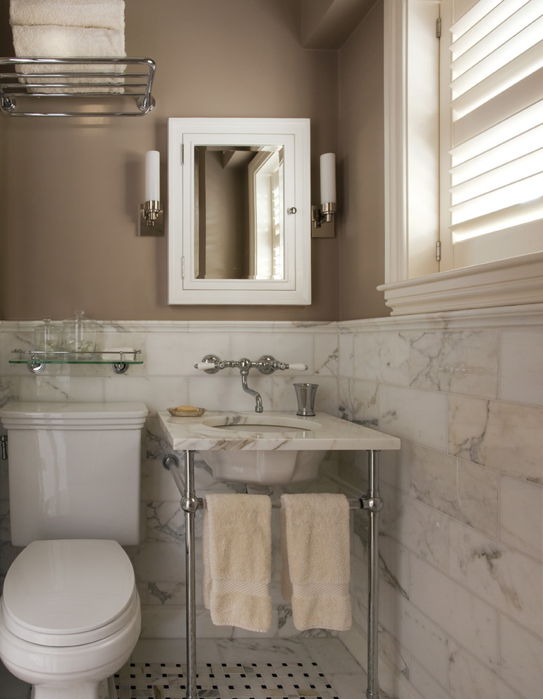 Example of a classic marble tile bathroom design in Boston with a console sink