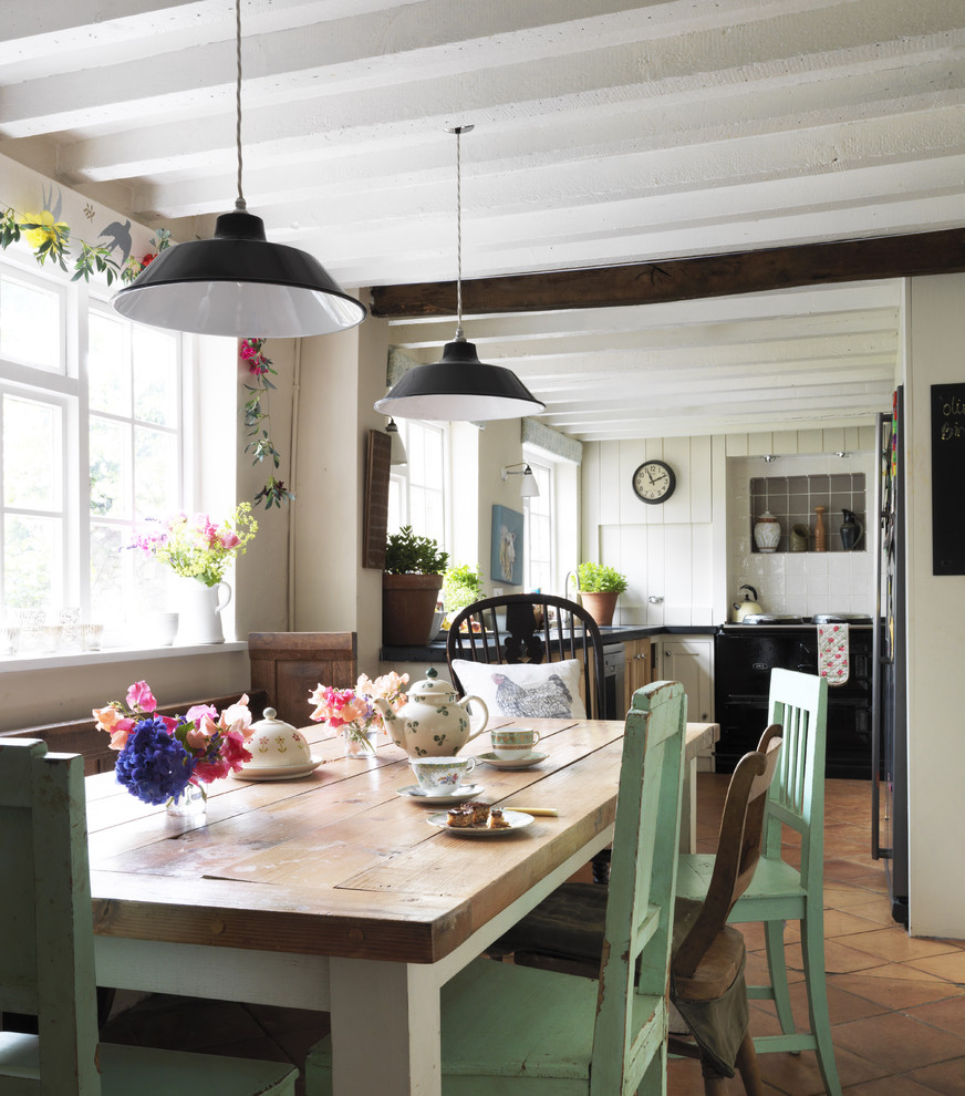 Example of a cottage chic terra-cotta tile kitchen/dining room combo design in London