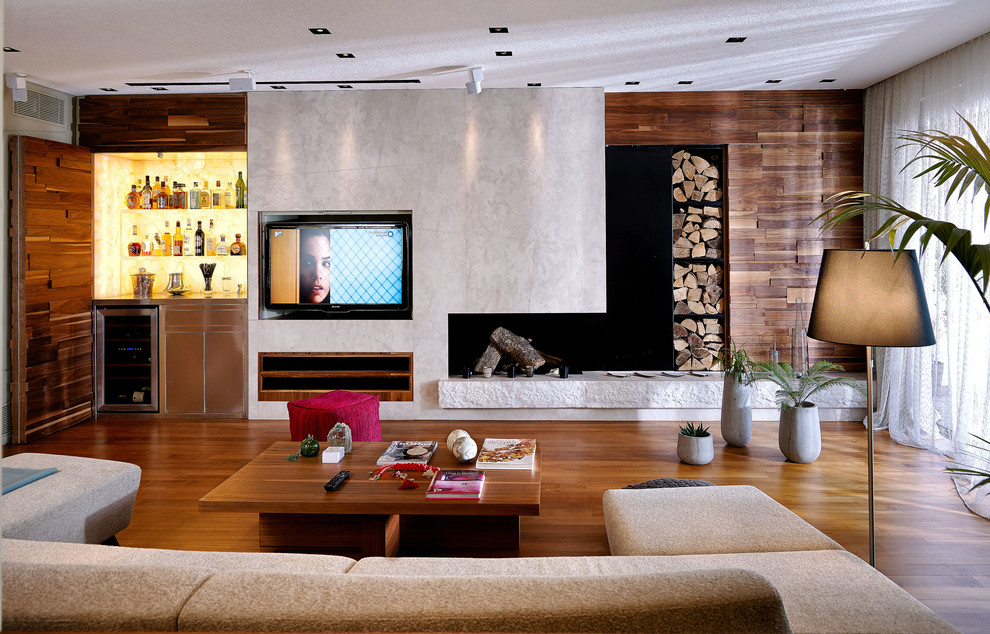 This is an example of a contemporary games room in London with a home bar, brown walls, medium hardwood flooring, a standard fireplace, a wall mounted tv and brown floors.
