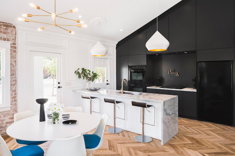 Inspiration for a contemporary galley light wood floor eat-in kitchen remodel in Phoenix with an undermount sink, flat-panel cabinets, dark wood cabinets, black appliances and an island