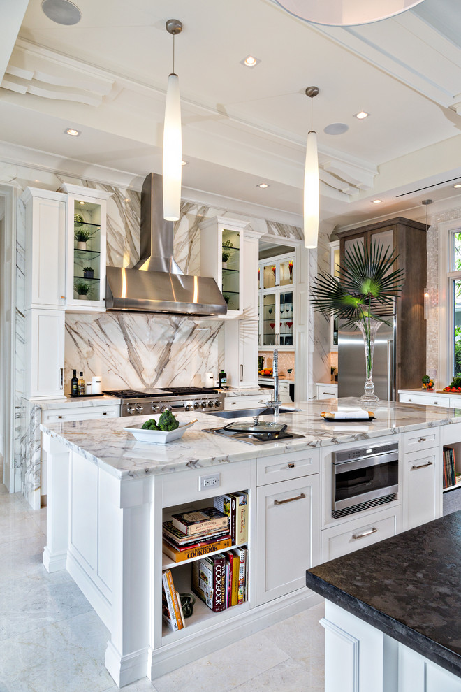 Enclosed kitchen - mid-sized contemporary galley marble floor and white floor enclosed kitchen idea in Miami with white cabinets, marble countertops, white backsplash, stone slab backsplash, stainless steel appliances, an undermount sink, shaker cabinets and an island