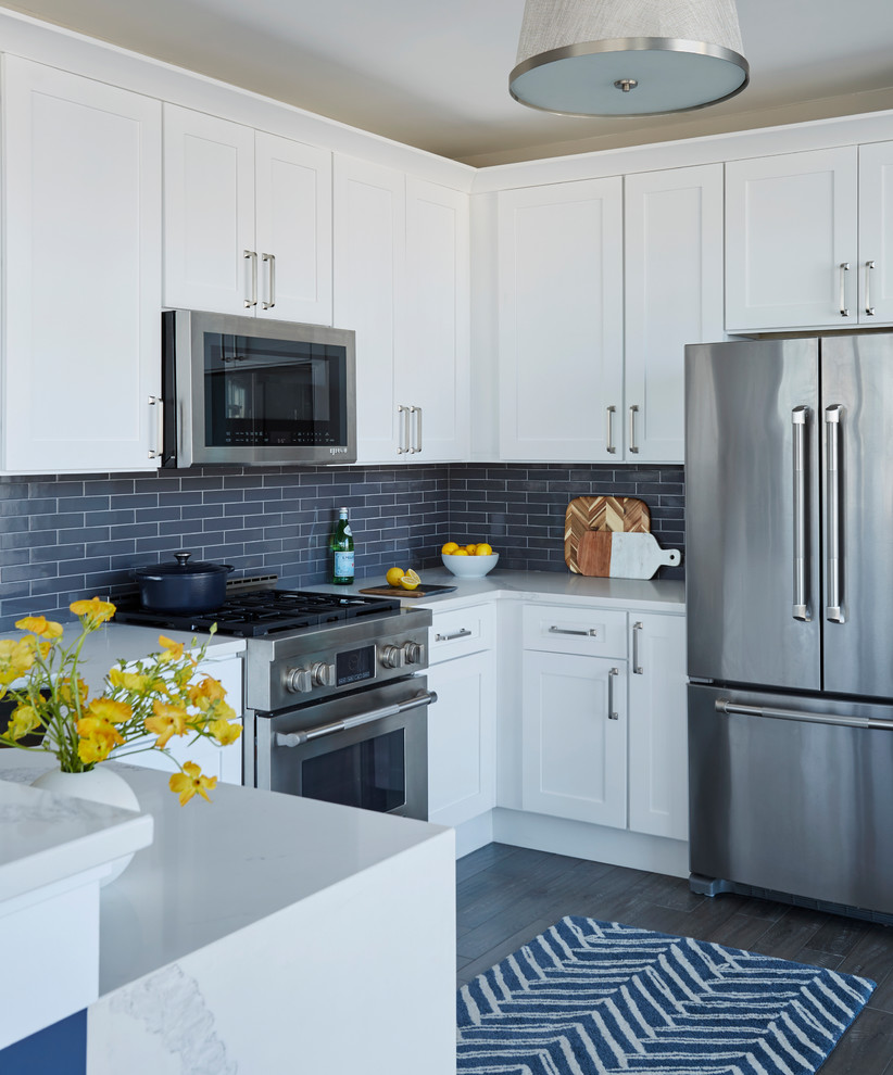 Inspiration for a mid-sized contemporary u-shaped gray floor and dark wood floor kitchen remodel in Chicago with shaker cabinets, white cabinets, quartz countertops, gray backsplash, ceramic backsplash, stainless steel appliances, a peninsula and white countertops