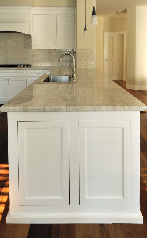 Inspiration for a large timeless u-shaped medium tone wood floor open concept kitchen remodel in Sacramento with an undermount sink, recessed-panel cabinets, white cabinets, quartzite countertops, beige backsplash, ceramic backsplash, stainless steel appliances and a peninsula