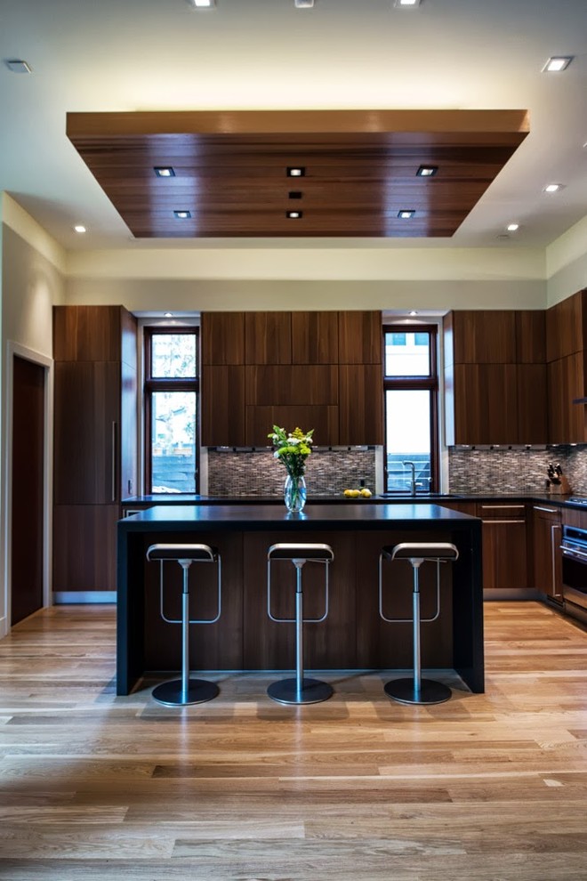 Example of a large trendy l-shaped light wood floor open concept kitchen design in DC Metro with flat-panel cabinets, dark wood cabinets, brown backsplash, mosaic tile backsplash, quartz countertops and stainless steel appliances