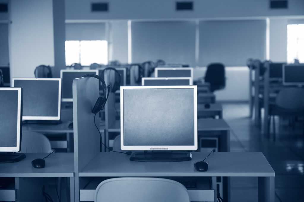 Rows of computer neatly placed in a computer lab.