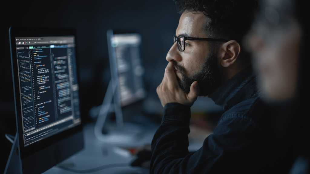 He Works on Desktop Computer in College. Applying His Knowledge in Writing Code, Developing Software.