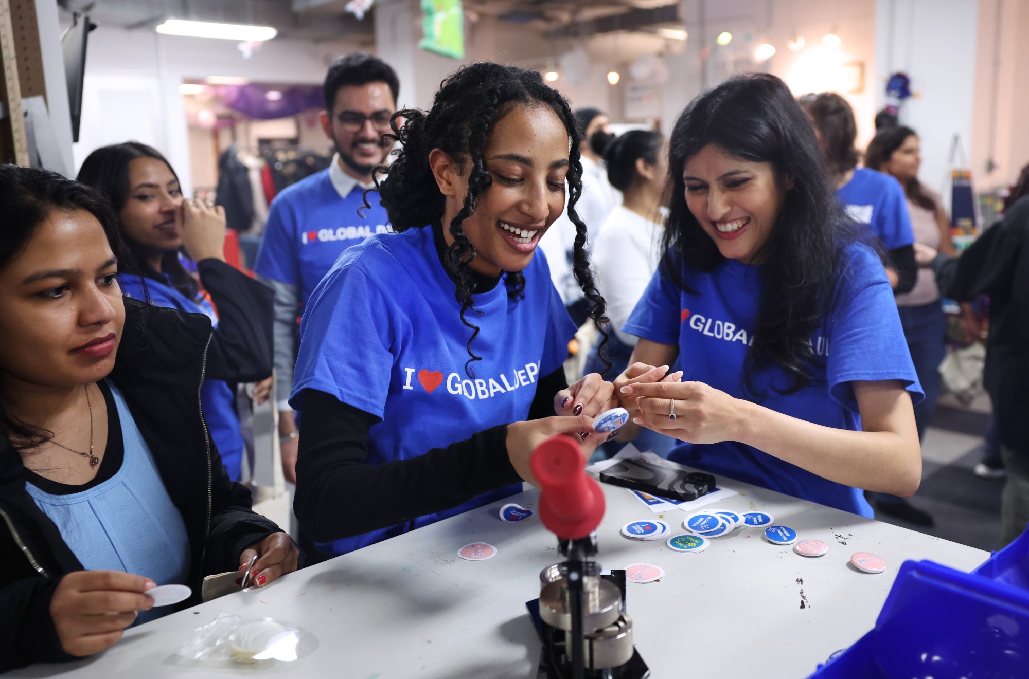 DePaul University students Beemnet Desta, center, and Suchita Farkiwala, right, laugh while making pins at a social gathering for international students at the school's downtown campus on Jan. 26, 2024. (Chris Sweda/Chicago Tribune)