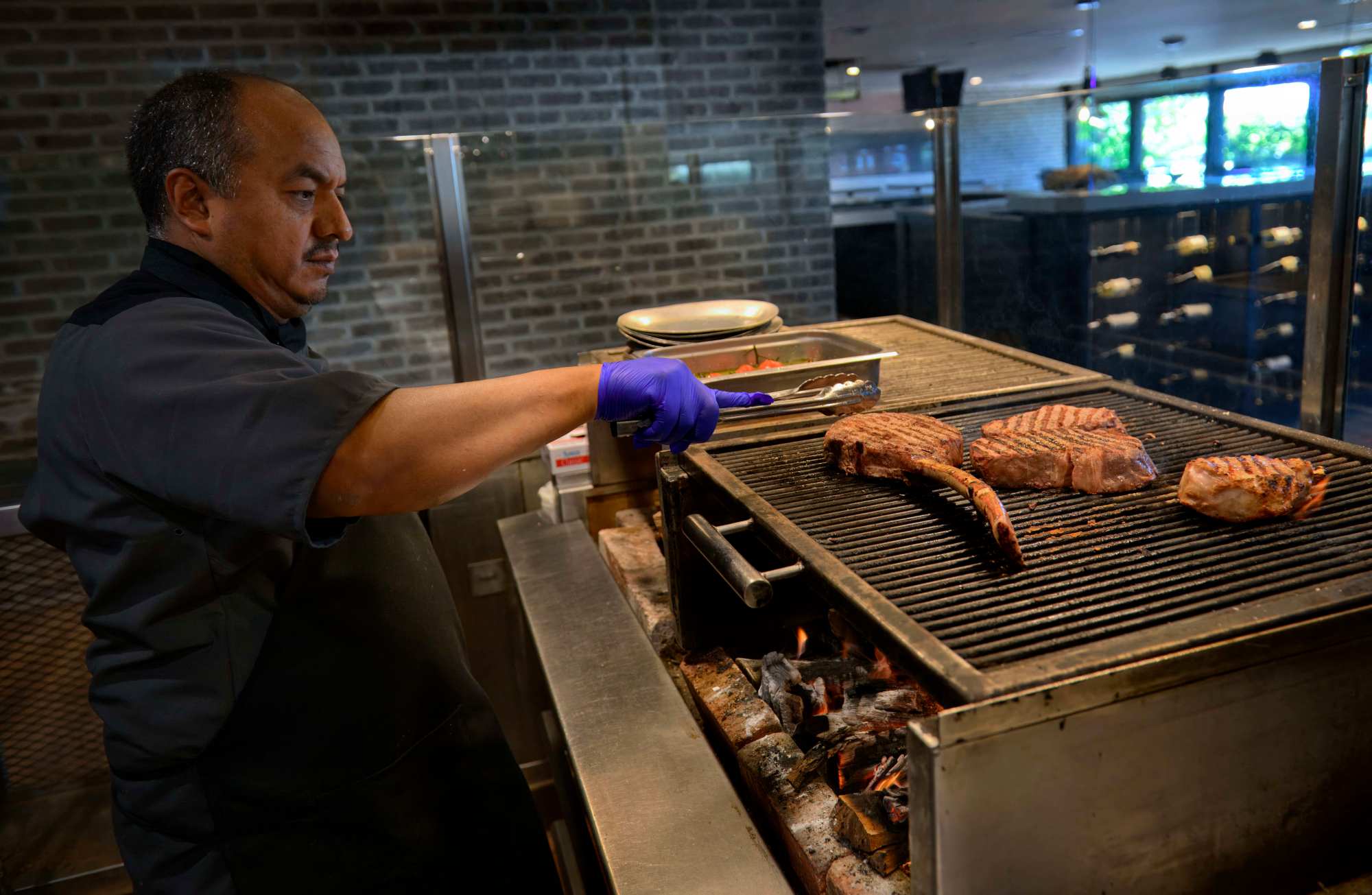 Jaime González, executive sous chef gets some cuts of beef started on the wood-fired grill at Salt Creek Grille in Dana Point on Friday, June 14, 2024. (Photo by Paul Rodriguez, Contributing Photographer)