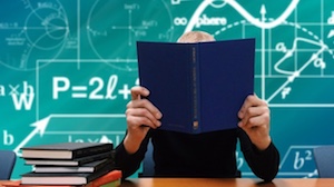 person holding book open on table