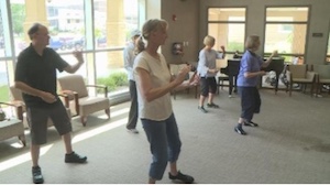 adults doing tai chi in classroom