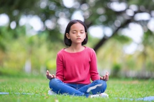 sitting child meditating 