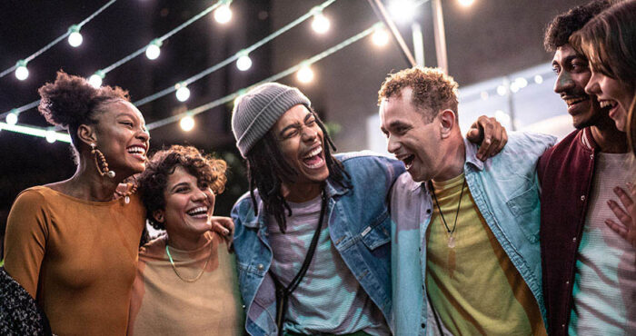 Friends embracing having fun in the street at night