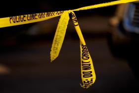Yellow crime scene tape with a knot in the middle.