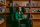 A portrait of Alice Newton-Rex, vice president of product at WhatsApp, at Meta’s corporate campus, wearing a green blazer seated infront of a wooden bookshelf.