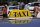 A close-up of a yellow taxi sign on top of a car, with the word 