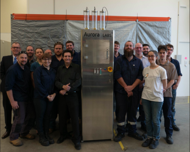 Aurora Labs team with their first printer to ship. Photo via Aurora Labs/Twitter.