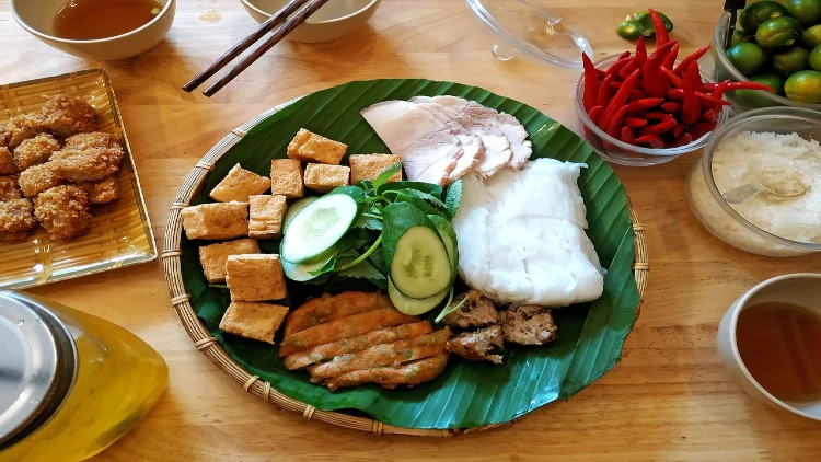 Tofu, beef, and vegetables on a woven wooden plate.