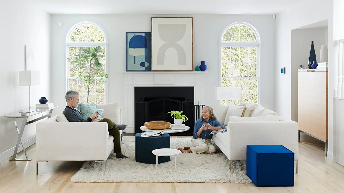 man sitting on couch looking at woman sitting on floor in living room during day time