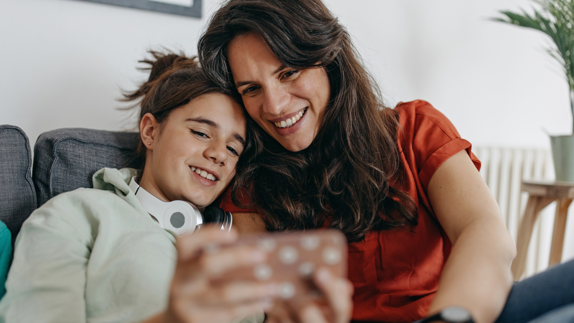 A parent and a child looking at a cell phone.