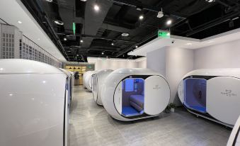 The room has white walls and a blue floor, with an air hockey board mounted on one of the walls at Ke Sleeping Lounge (Beijing Daxing Airport Terminal)