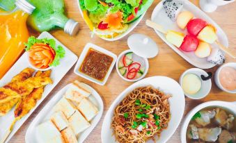 The table on the top left is full of dishes and food, including an appetizer at Panwaburi Beachfront Resort