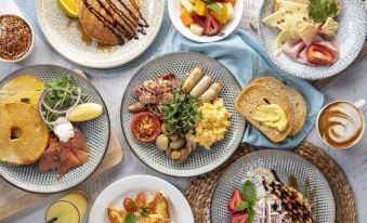 a table is filled with various plates of food , including a variety of breakfast items at Sea World Resort